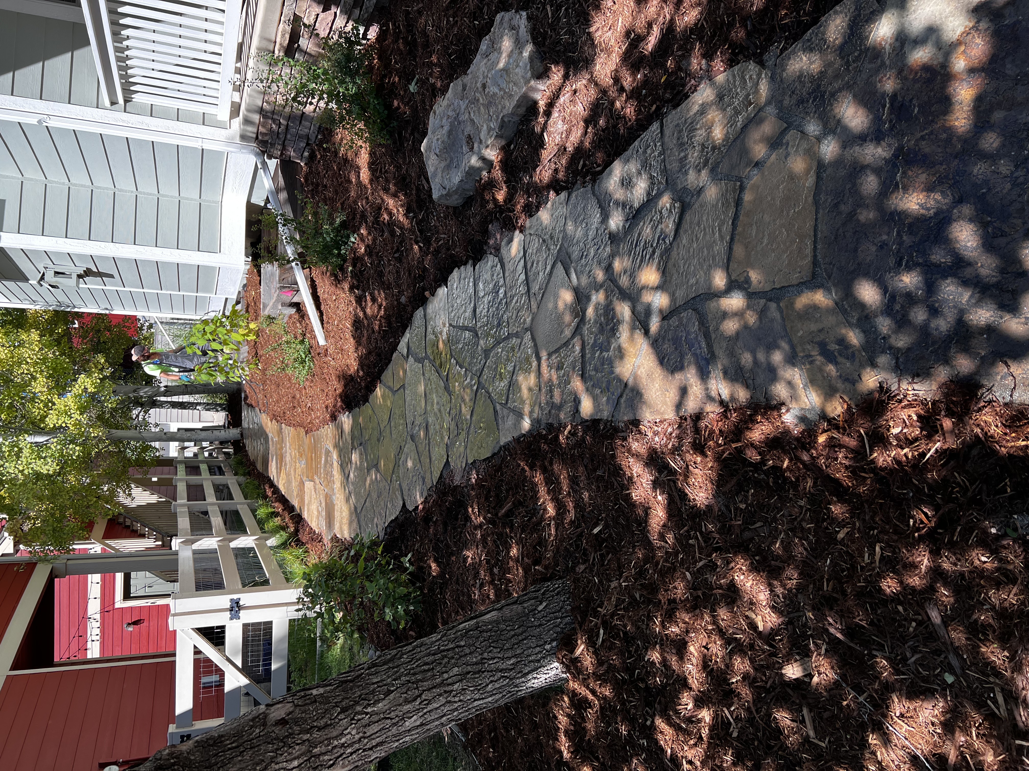 Natural stone walkway installation with mulch beds